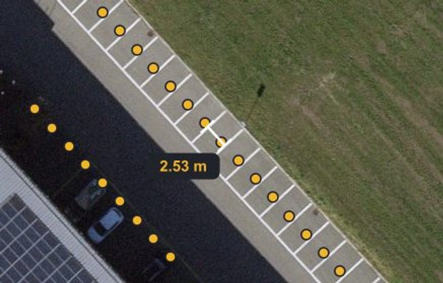 Aerial photo of a Swiss parking row: yellow dots mark each known spot, a dimension line shows a measured bay width of 2.59 meters
